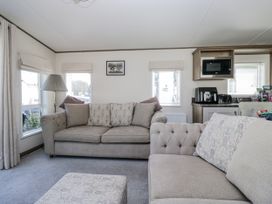 A living room with a sofa and a microwave at Lilac Lodge in Carnforth