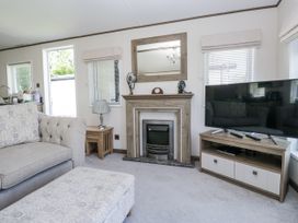 A living room with a sofa and fireplace at Lilac Lodge in Carnforth