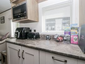 A kitchen countertop with appliances and brochures at Lilac Lodge in Carnforth