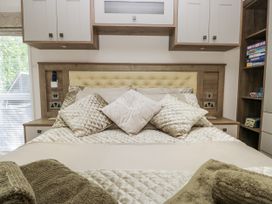 A bedroom with a bed and bedside tables at Lilac Lodge Carnforth