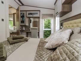 A bedroom with a bed and desk at Lilac Lodge in Carnforth