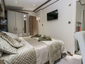 A bedroom with a bed and wardrobe at Lilac Lodge in Carnforth