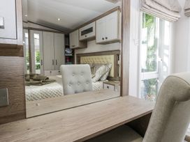 A bedroom with a bed and dresser at Lilac Lodge Carnforth