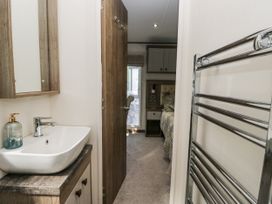 A bathroom with a sink and mirror at Lilac Lodge in Carnforth