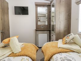 A bedroom with two beds and a television at Lilac Lodge Carnforth