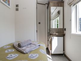 A bedroom with a bed and towels at Lilac Lodge Carnforth