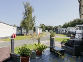 An outdoor area with seating and caravans at Lilac Lodge in Carnforth