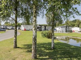 An outdoor view of caravans and trees at Lilac Lodge in Carnforth