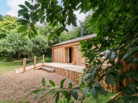 A wooden cabin with a deck and entrance at Brambly Cabin in Crediton