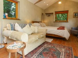 A bedroom with a bed and sofa at Brambly Cabin in Crediton