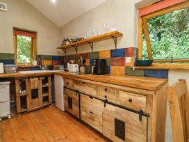 A kitchen with wooden cabinetry and appliances at Brambly Cabin in Crediton