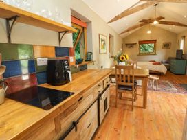A kitchen with wooden furniture and a coffee maker at Brambly Cabin in Crediton
