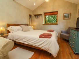 A bedroom with a bed and lamp at Brambly Cabin in Crediton