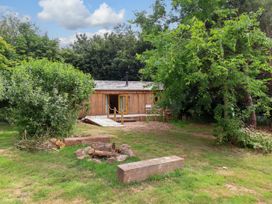 A cabin surrounded by trees and bushes at Brambly Cabin in Crediton