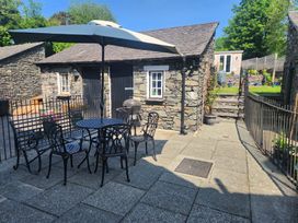 An outdoor area with a table and chairs and a stone wall at 6 Calgarth View Windermere