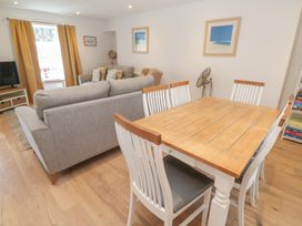 A living room with a sofa and dining table at Foundry Cottage In Hayle Harbour Hayle