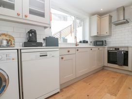 A kitchen with appliances including a washing machine and dishwasher at Foundry Cottage In Hayle Harbour Hayle