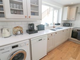 A kitchen with appliances and cabinets at Foundry Cottage In Hayle Harbour Hayle