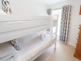 A bedroom with a bunk bed and curtains at Foundry Cottage In Hayle Harbour, Hayle