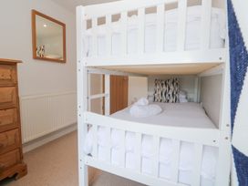 A bedroom with a bunk bed and a mirror at Foundry Cottage In Hayle Harbour, Hayle