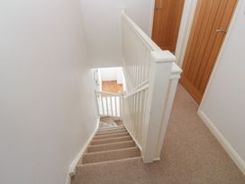 A staircase with a handrail and doors at Foundry Cottage In Hayle Harbour, Hayle