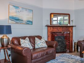 A living room with a sofa and a fireplace at Waders in Salcombe