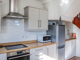 A kitchen with a stove, microwave, and refrigerator at Waders in Salcombe