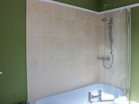 A bathroom with a bathtub and shower at Waders in Salcombe