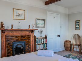 A bedroom with a fireplace and bookshelf at Waders in Salcombe