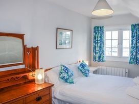 A bedroom with a bed and dresser at Waders in Salcombe