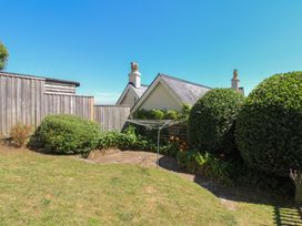 A garden with a clothesline and bushes at Waders, Salcombe