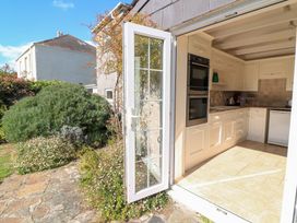 A kitchen with modern appliances and an open door at Wayside near Kingsbridge