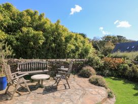 A garden with a wooden bench and table at Wayside near Kingsbridge