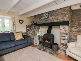 A living room with a fireplace and sofa at Wayside near Kingsbridge