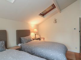 A bedroom with two beds and a lamp at Wayside near Kingsbridge
