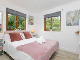 A bedroom with a bed and windows at Branock, Tor Down Quarry in St Breward