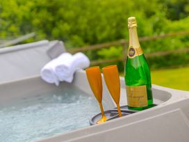 A hot tub with champagne and glasses at Branock, Tor Down Quarry, St Breward
