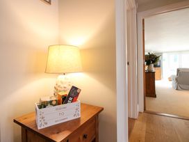 A hallway with a lamp and a welcome basket at Welsummer in Salcombe