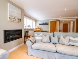 A living room with a sofa and fireplace at Welsummer in Salcombe