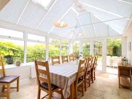A conservatory with a dining table and chairs at Welsummer in Salcombe