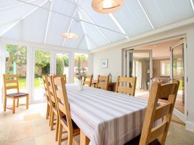 A conservatory with a table and chairs at Welsummer in Salcombe