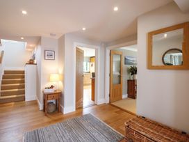 A hallway with a staircase and a lamp at Welsummer in Salcombe