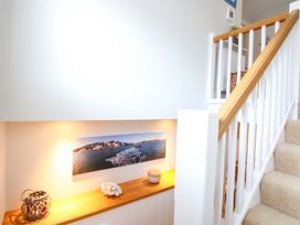 A stairway with a decorative shelf and photo at Welsummer Salcombe