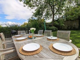 An outdoor dining table set with plates and glasses at Welsummer Salcombe