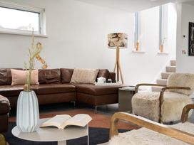 A living room with a sofa and a lamp at Estuary Watch in Lelant near Carbis Bay
