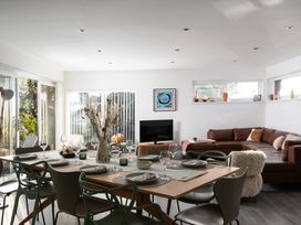 A dining room with a table set and a sofa at Estuary Watch in Lelant near Carbis Bay