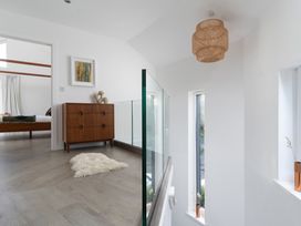 A hallway with a drawer unit and wall art at Estuary Watch in Lelant near Carbis Bay