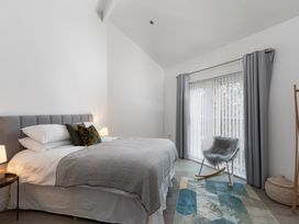 A bedroom with a bed and sliding door at Estuary Watch in Lelant near Carbis Bay