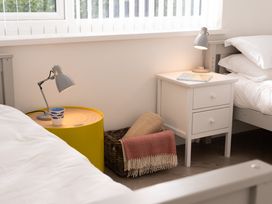 A bedroom with two beds and bedside tables at Estuary Watch in Lelant near Carbis Bay