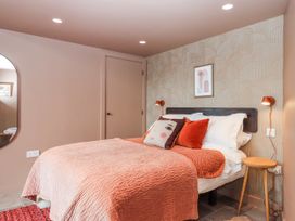 A bedroom with a bed and wall art at 3 Caddaford Barns in Buckfastleigh
